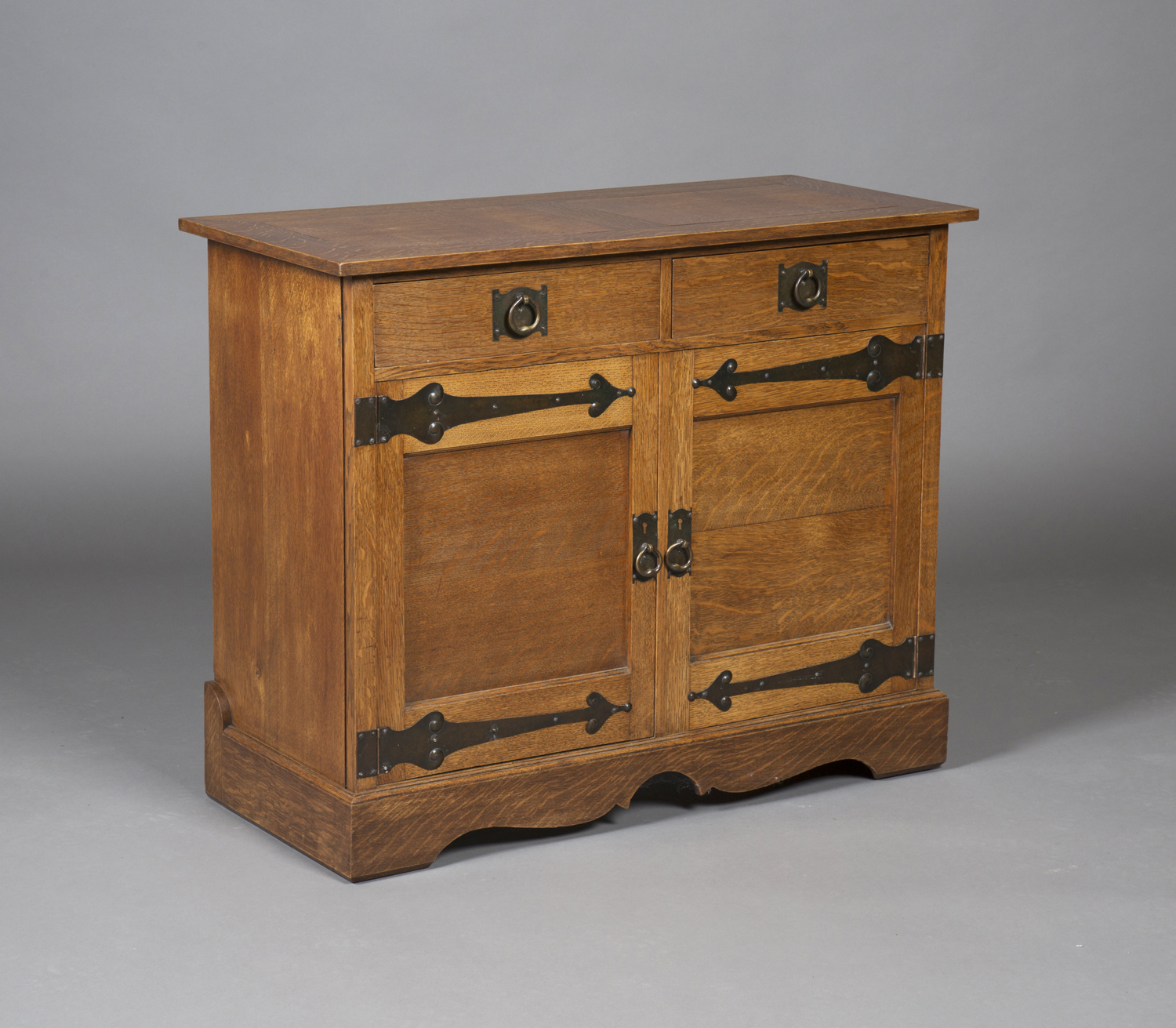 An early 20th century Arts and Crafts oak side cabinet, possibly by the Guild of Handicraft,