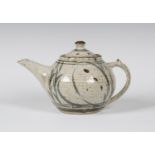 A Rupert Spira studio pottery stoneware teapot and cover, the pitted off-white ground decorated with