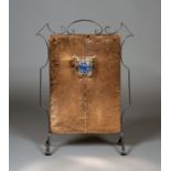 An Arts and Crafts copper and wrought iron firescreen, the hammered panel inset with a Ruskin