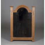 An Edwardian Arts and Crafts oak wall mirror by Shapland & Petter of Barnstaple, the bevelled