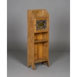 An early 20th century Arts and Crafts oak narrow bookcase, in the manner of Liberty & Co, fitted