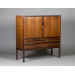 A mid-20th century rosewood side cabinet, possibly by Gordon Russell, the two doors enclosing four