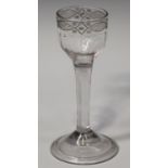 An engraved plain stem wine glass, mid-18th century, the panel moulded ogee bowl engraved with a