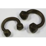 A pair of African bronze manillas with engraved faceted terminals, width 11cm.Buyer’s Premium 29.