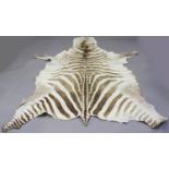 An early/mid-20th century zebra skin, length 260cm, width 190cm, together with half a sable skin.