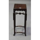 A Chinese hardwood stand, early 20th century, the square panelled top above a carved ruyi head