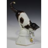 A Thuringian Katzhutte porcelain cat, first half of the 20th century, modelled on a pedestal playing