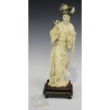 A Chinese carved and stained ivory figure of a maiden, early 20th century, modelled standing wearing