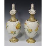 A pair of Wedgwood pottery ewers, 1870s, the cream ovoid bodies decorated with daffodils between the