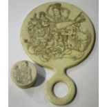 A Japanese ivory handmirror, Meiji/Taisho period, of circular form with loop handle, the back finely