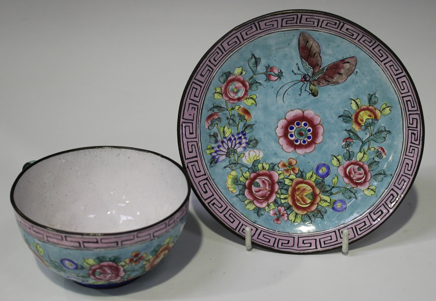 A Chinese Canton export enamel teacup and saucer, late Qing dynasty, each piece painted in famille