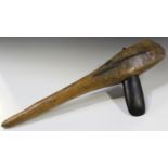 A New Guinea ethnic polished stone axe head, mounted in a tapering wooden shaft, length 71cm.Buyer’s