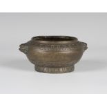 A Chinese brown patinated bronze censer, Qing dynasty, of squat circular form, cast with lappet