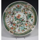 A Chinese famille verte porcelain circular dish, early 20th century, painted with panels of peonies,