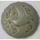 A Chinese pale celadon jade circular pendant, carved and pierced with a crane flying amidst lotus