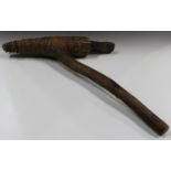 A Papua New Guinea digging axe, the carved stone head bound to a long wooden handle with rattan,