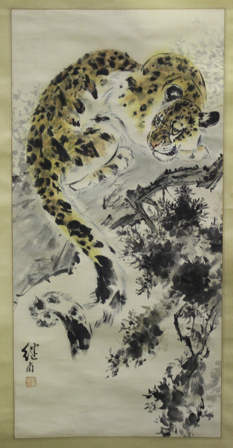 A Chinese hanging scroll painting, 20th century, depicting a leopard resting on a tree branch, black