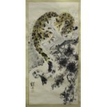 A Chinese hanging scroll painting, 20th century, depicting a leopard resting on a tree branch, black