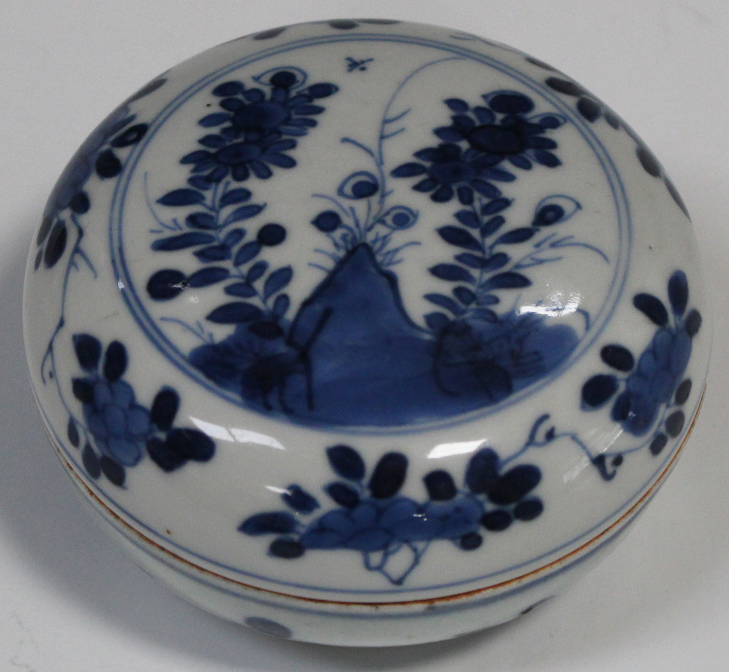 A Chinese blue and white circular box and cover, Kangxi period, the top painted with flowers and