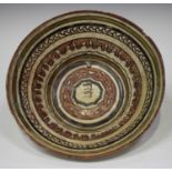 A Nishapur pottery bowl, possibly 11th century, the centre painted in dark brown with a panel of