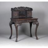 A Chinese hardwood writing desk with carved blossoming prunus decoration, late 19th century, the