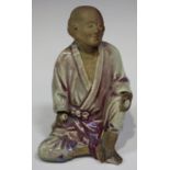 A Chinese pottery figure of a gentleman, late 19th/early 20th century, modelled in a seated pose