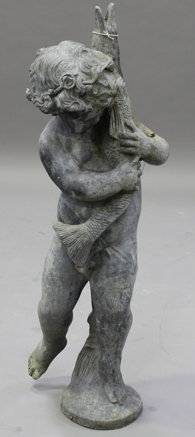 An early 20th century lead garden fountain figure of a standing putto holding a pike, height 98cm.
