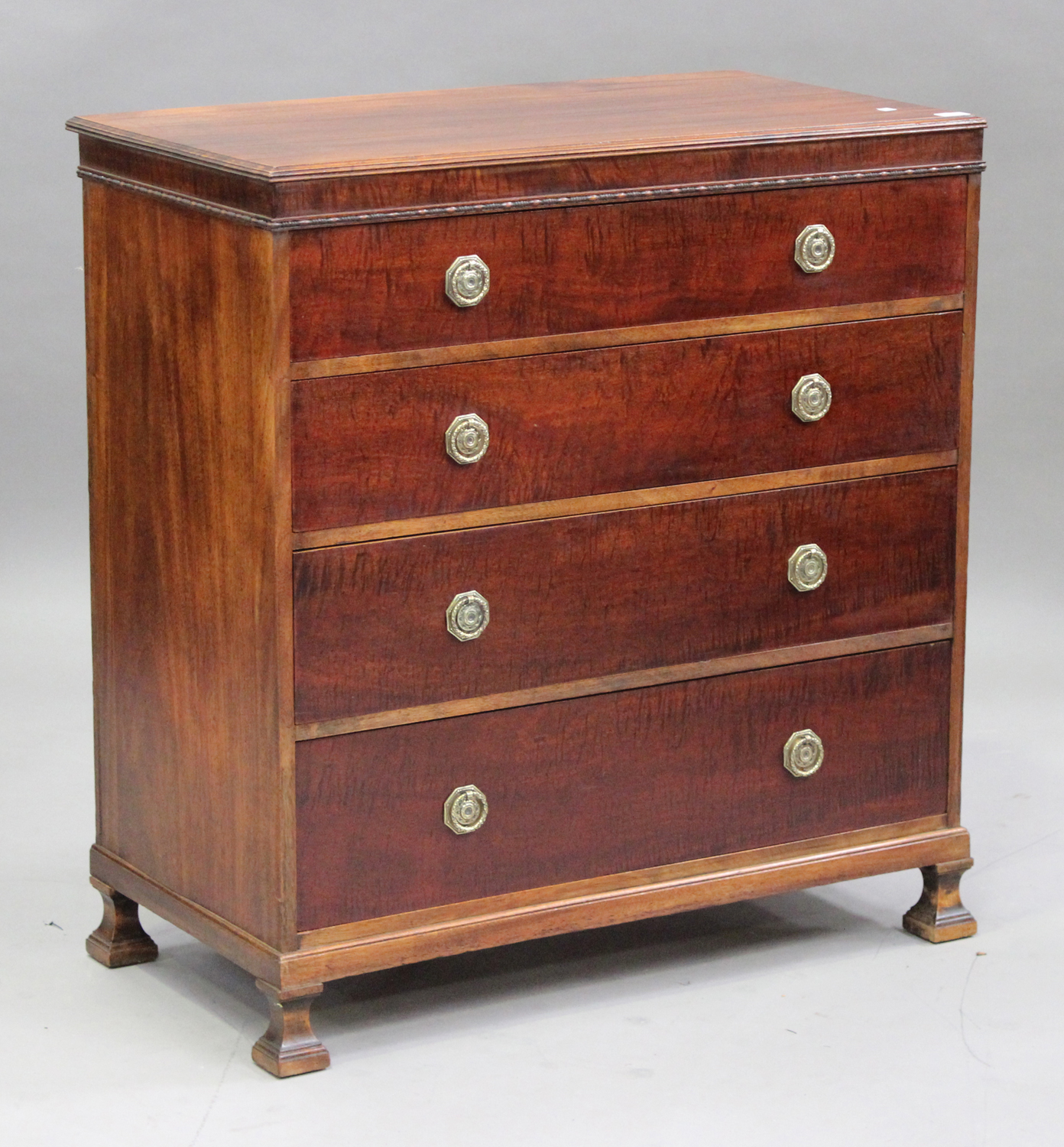 An early 20th century mahogany chest of four long graduated drawers by Waring & Gillow Ltd, raised