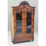 A 19th century figured mahogany vitrine, the moulded arch pediment applied with a leaf scroll