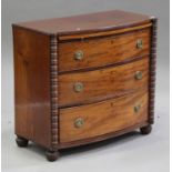 A late George III mahogany bowfront chest with brushing slide above three graduated long drawers,