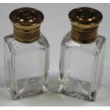 A pair of early Victorian clear glass and silver gilt mounted scent bottles, London 1851, each