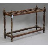 An Edwardian pitch pine clubhouse stick stand, on turned and block supports united by stretchers,