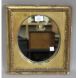 A 19th century gilt composition rectangular wall mirror, the beaded frame with an oval plate