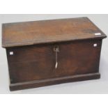 A 19th century oak trunk, the hinged lid revealing a candle compartment, on a plinth base, height