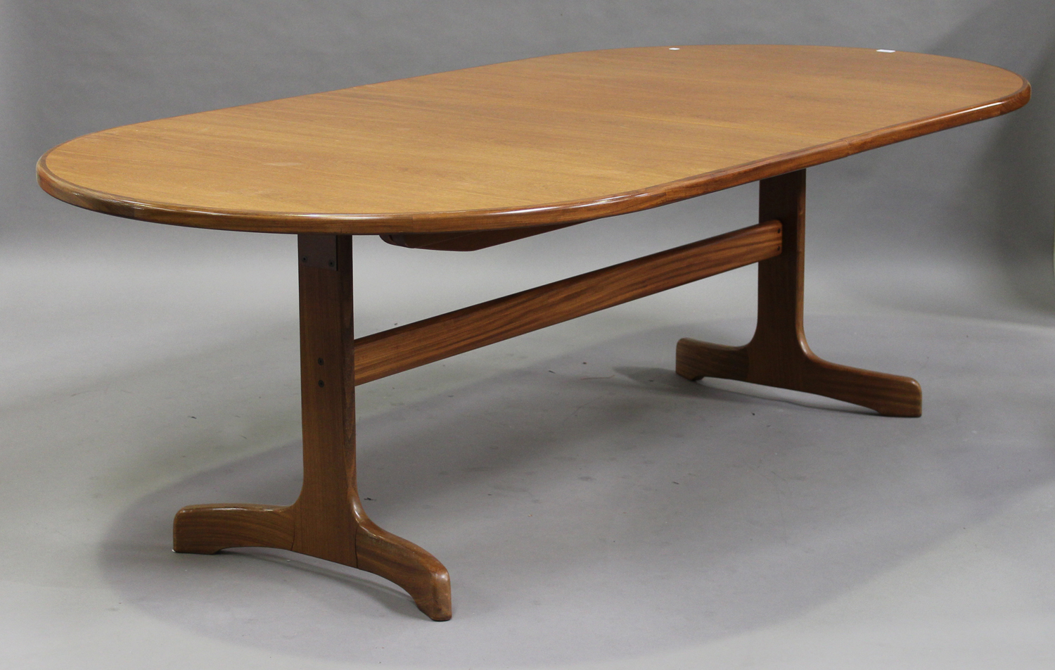 A late 20th century G-Plan teak extending dining table with an extra leaf, raised on shaped