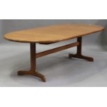 A late 20th century G-Plan teak extending dining table with an extra leaf, raised on shaped