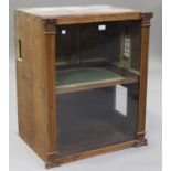 A late 19th century glazed cabinet, the interior fitted as a two-level doll's house, the door with