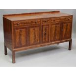 An early 20th century figured mahogany sideboard by Heals, the crossbanded top above three drawers