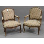 A pair of late 19th/early 20th century French stained beech fauteuil armchairs with carved