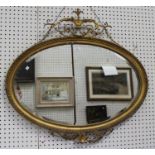 A 19th century giltwood and gesso oval wall mirror with floral scrolling surmount and apron, 82cm