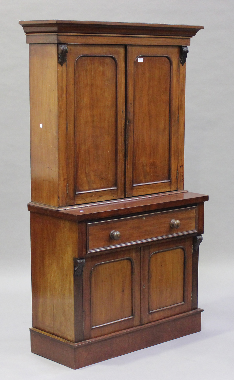 A Victorian mahogany bookcase cabinet, the moulded pediment above a pair of panel doors, the base