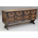 A 20th century Jacobean style oak sideboard, carved with flowers and leaves, fitted with drawers and