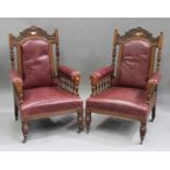 A pair of Edwardian oak framed salon armchairs with carved decoration, each upholstered in claret