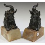 A pair of French Art Deco anodized cast spelter and pink toned onyx bookends, each modelled in the