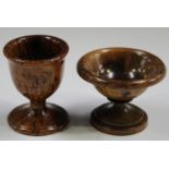 A 19th century turned treen egg cup with flared circular foot, height 6.6cm, together with a