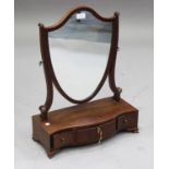 A 19th century mahogany shield shaped swing frame toilet mirror, the serpentine fronted base