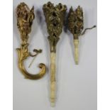 A late 19th century gilded pressed metal posy holder, the scrolling handle issuing a pierced acorn