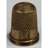 A Victorian gold thimble, the band engraved with initials alternating with decorated panels,