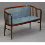 An Edwardian mahogany framed two-seat salon settee, upholstered in blue velour, on square tapering