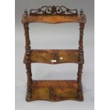 A late Victorian walnut graduated three-tier wall shelf with fretwork frieze and acorn finials,